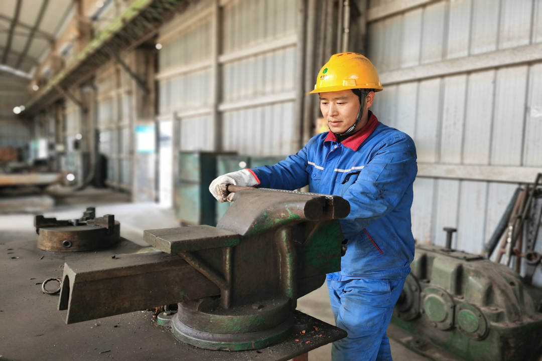 胡曉云正在鉗臺(tái)上矯正鋼管.jpg 胡曉云正在鉗臺(tái)上矯正鋼管.jpg